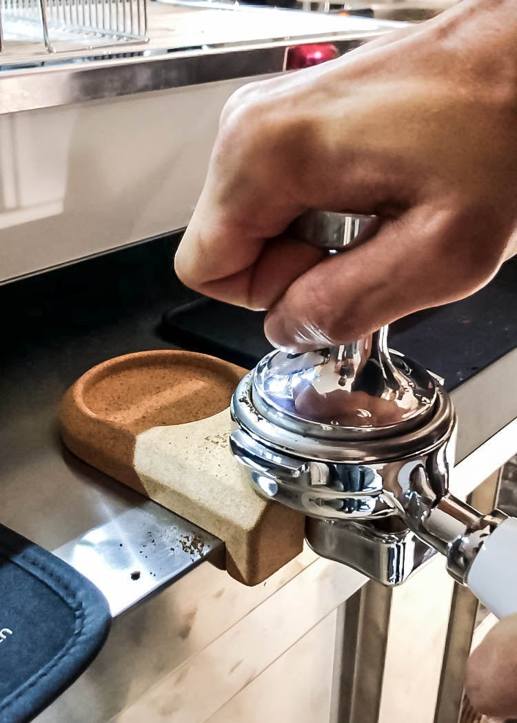 Tamping mat cork used in front of a espresso machine and with a portafilter and a tamper 